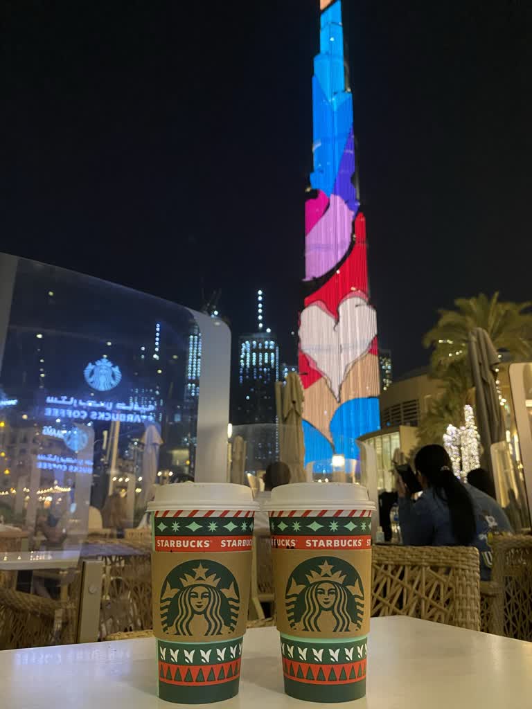 一栋高楼前的桌子上摆着两杯咖啡